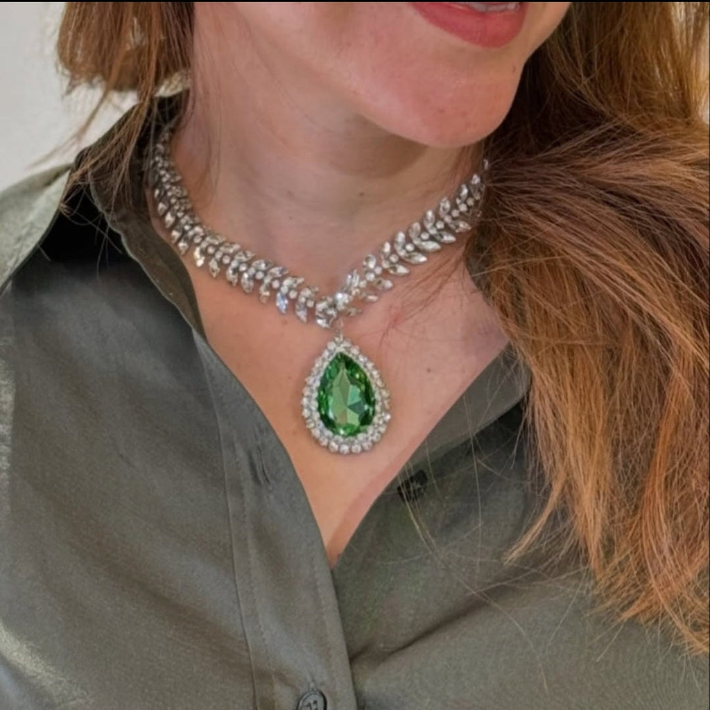 Model wearing the Emerald Teardrop Necklace with a forest green crystal pendant, demonstrating the elegant fit and shimmering leaf-style vine chain.